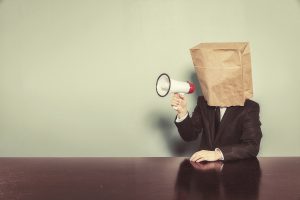 Businessman wearing paper bag in head with megaphone